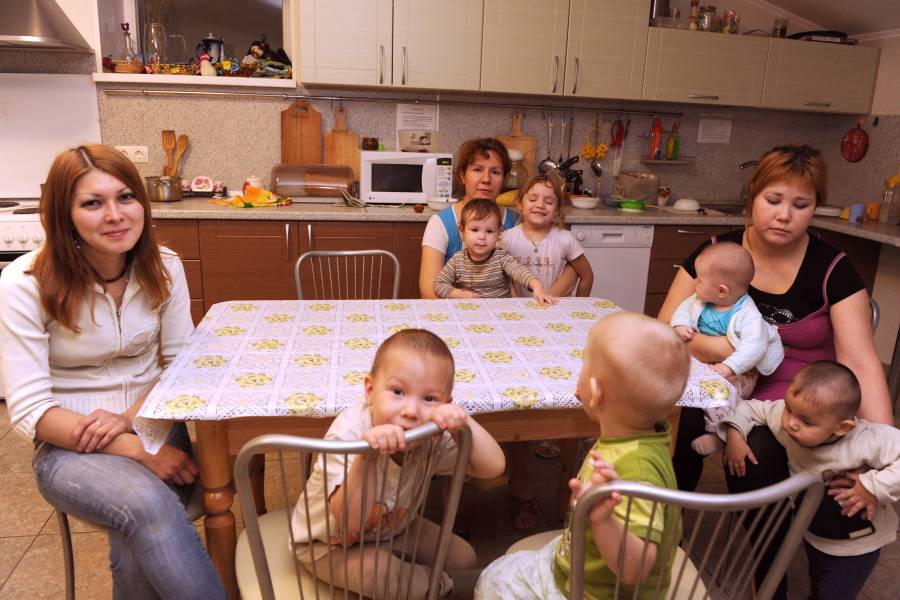 Frauen und Kinder an einem Küchentisch