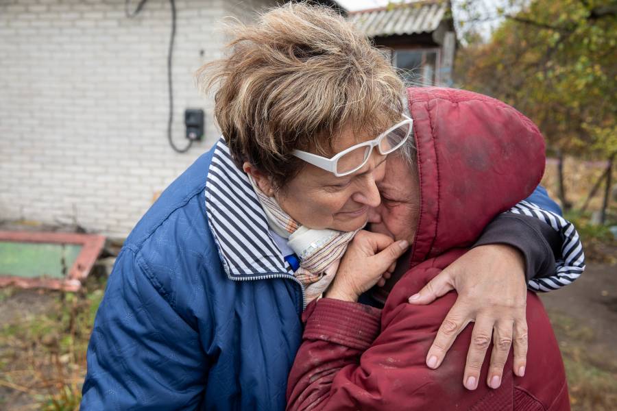 Olena Nebeska von der Caritas in Severodonetsk umarmt und tröstet die weinende 72-jährige Irina vor ihrem kriegsbeschädigten Haus in Bobrove.