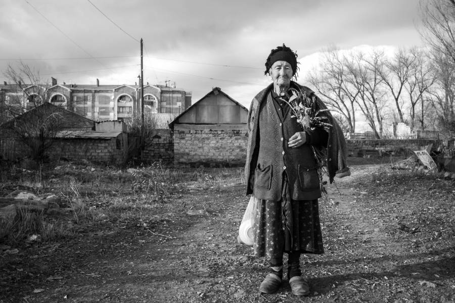 Schwarzweiß-Foto einer alten Frau mit einem Blumenstrauss im Norden Armeniens