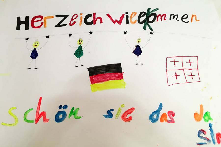 Von Kindern gebasteltes Willkommens-Plakat mit Deutschlandfahne