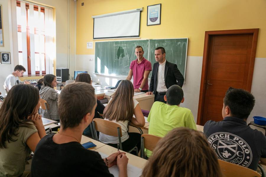 Schüler an der katholischen Privatschule Sankt Josef in Sarajevo, Bosnien und Herzegowina. Vor der Klasse stehen ein Lehrer und der Schuldirektor, Rev. Mario Cosic.