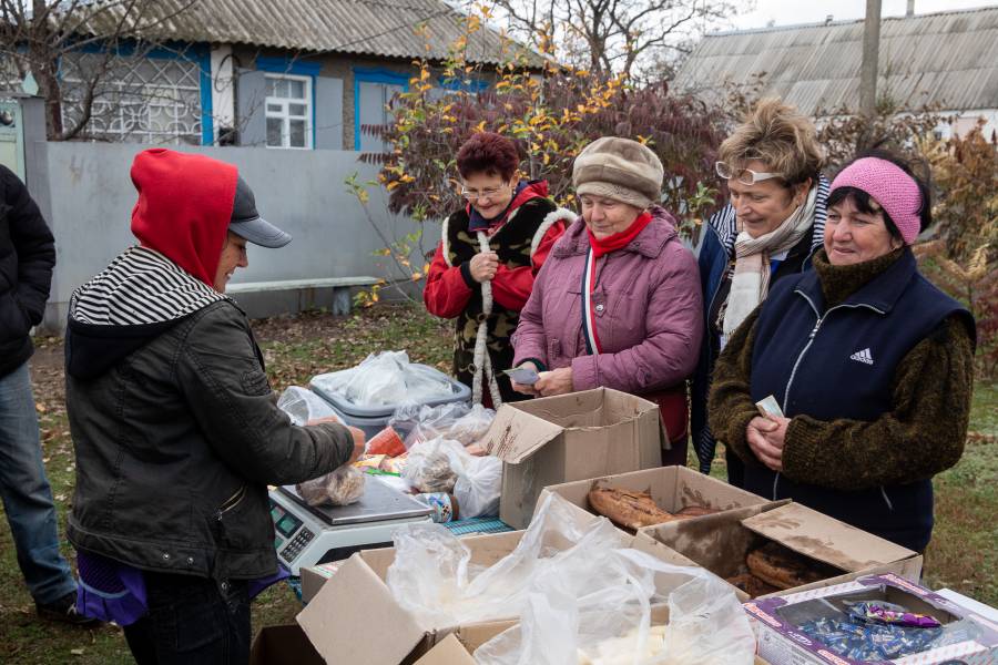 Olena Nebeska (2.v.r.) von der Caritas Severodonetsk zusammen mit Frauen an einem ambulanten Laden, an dem es u.a. Fisch gibt, in Bobrove.