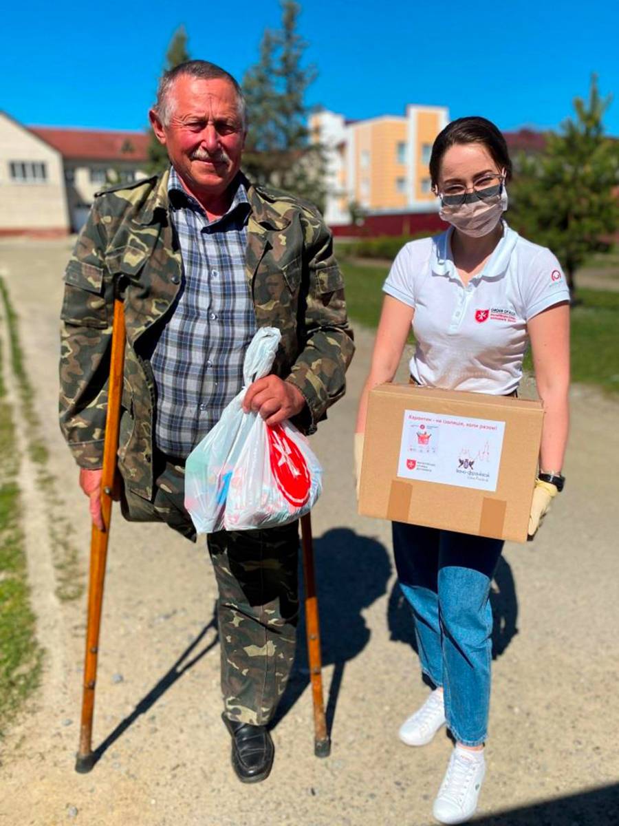 Junge Frau bringt ein Paket zu einem Mann mit Krücke