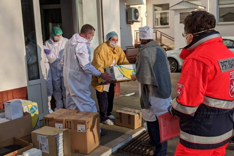 Die Malteser-Helfer bringen Kisten mit Hilfsmaterial in eine medizinische Einrichtung.