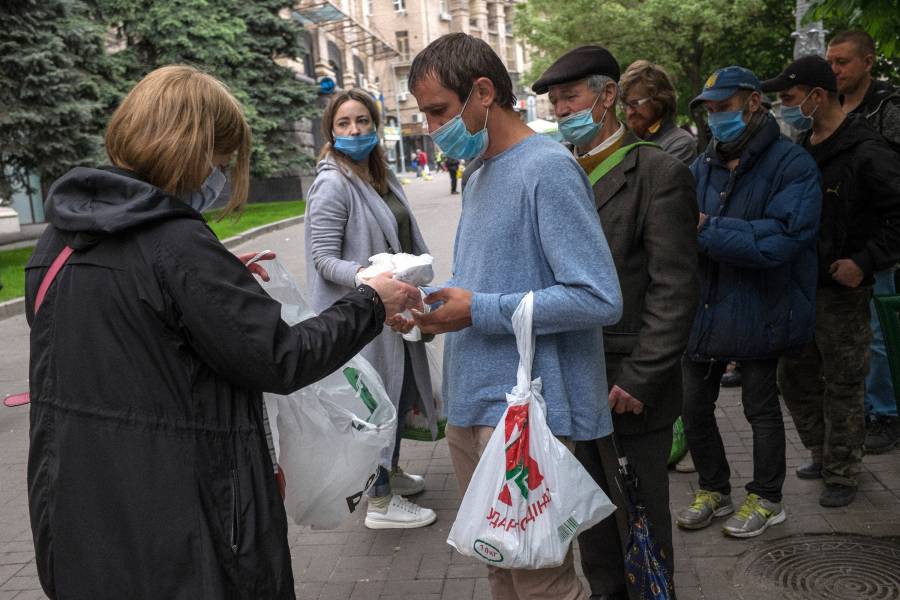 Obdachlose am Maidan bekommen Tüten mit Lebensmitteln.