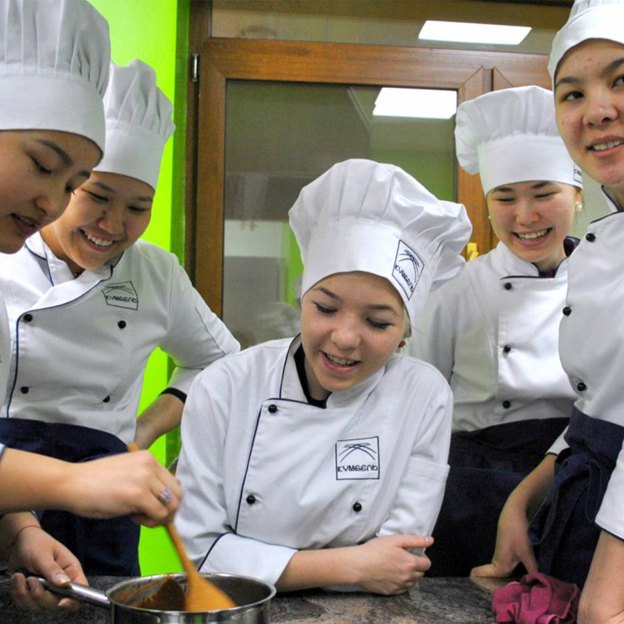 Junge Frauen mit Kochmütze in einer Küche