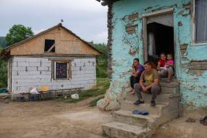 Familie auf den Treppenstufen ihres Hauses in Rumänien