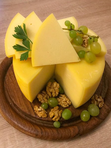 Holzbrettchen mit Käse, Nüssen und Weintrauben