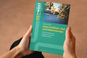 Zwei Hände halten die vierte OWEP-Ausgabe im Jahr 2021 zum Thema Seen in Mittel-, Ost- und Südosteuropa
