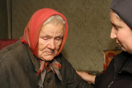 Ordensschwester kümmert sich um eine alte Frau