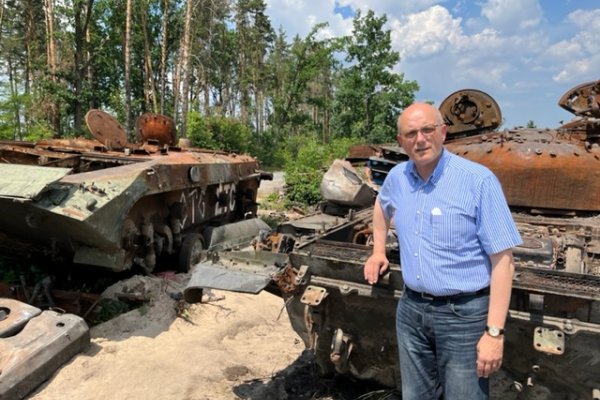 Pfarrer Schwartz vor ausgebrannten russischen Panzern in der Nähe von Kiew.