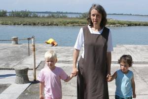 Ordensfrau mit zwei Kindern am Wasser