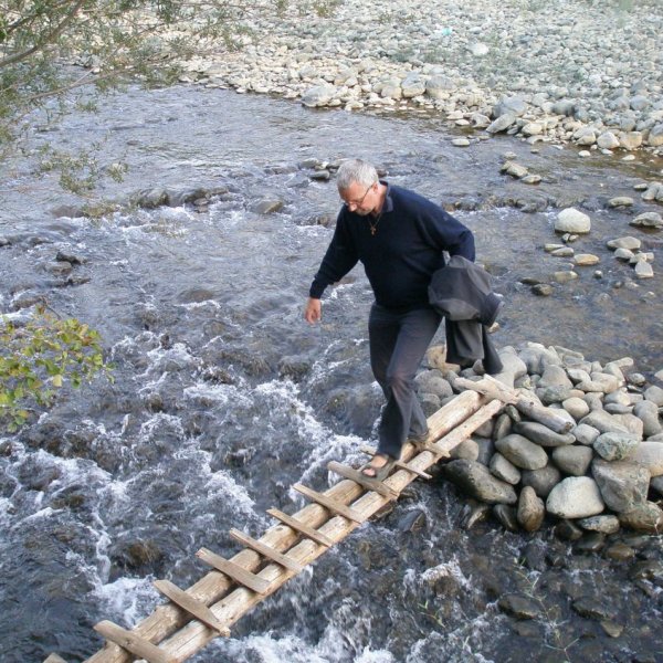 Mann überquert eine schmalen Holzsteg