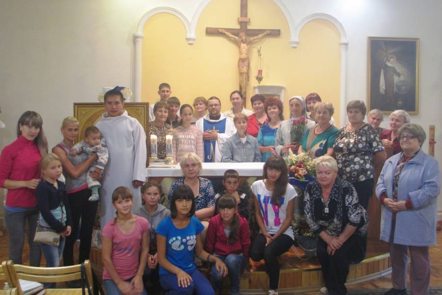 Gruppenbild der Gemeindemtiglieder von St. Raphael vor dem Altar der Kapelle.