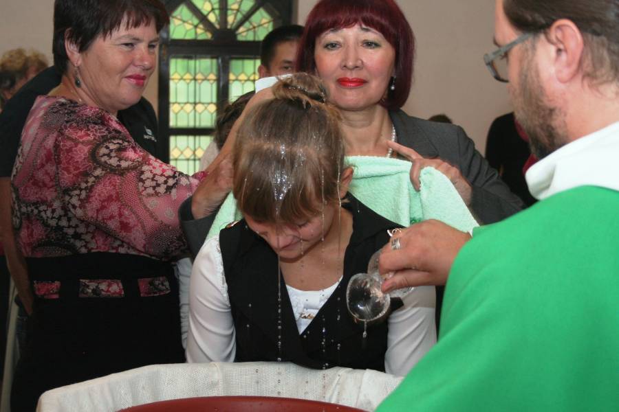 Pater Pawel tauft ein junges Mädchen in seiner Gemeinde.