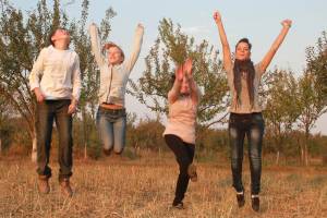Vier Kinder bzw. Jugendliche machen einen Luftsprung