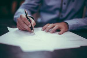 Close-up: Man signs a document