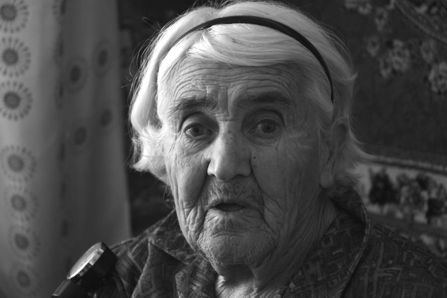 Portrait einer alten Frau in ihrer Wohnung.
