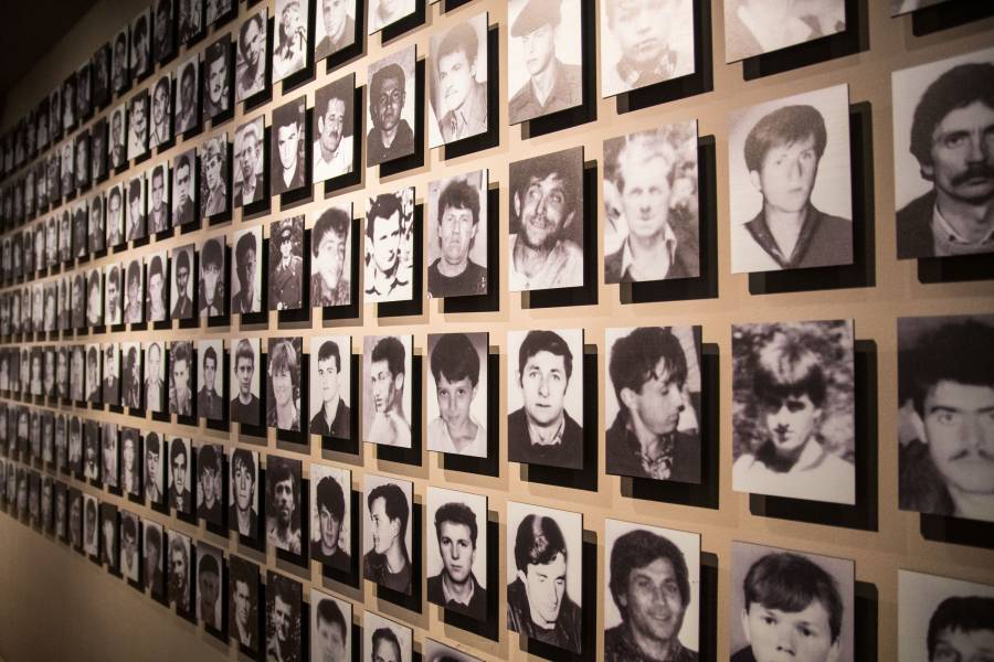 Eine Wand mit Fotos der Opfer von Srebrenica in der Dauerstellung „GALERIJA 11/07/95“