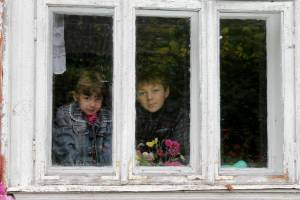 Kinder schauen aus einem Fenster