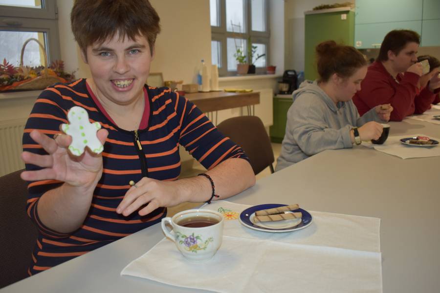 Junge Frau hält Plätzchen in die Kamera