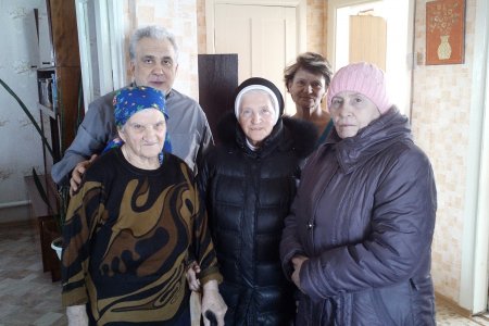 Gruppenbild in einer Wohnung mit einem Priester, einer Ordensschwester und drei Gemeindemitgliedern aus Berds.