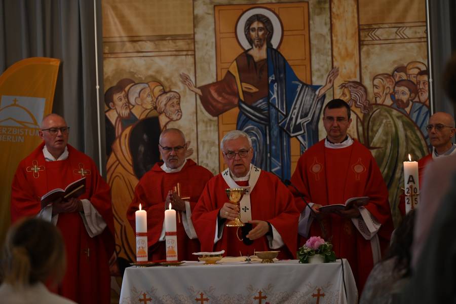 Das Bild zeigt fünf Männer in priesterlichen Gewändern nebeneinander während eines Gottesdienst. Hinter ihnen ist ein Bild von Jesus Christus angebracht.