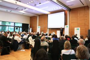 Blick in den vollbesetzten Veranstaltungssaal beim Renovabis-Kongress, vorne eine Person am Rednerpult.
