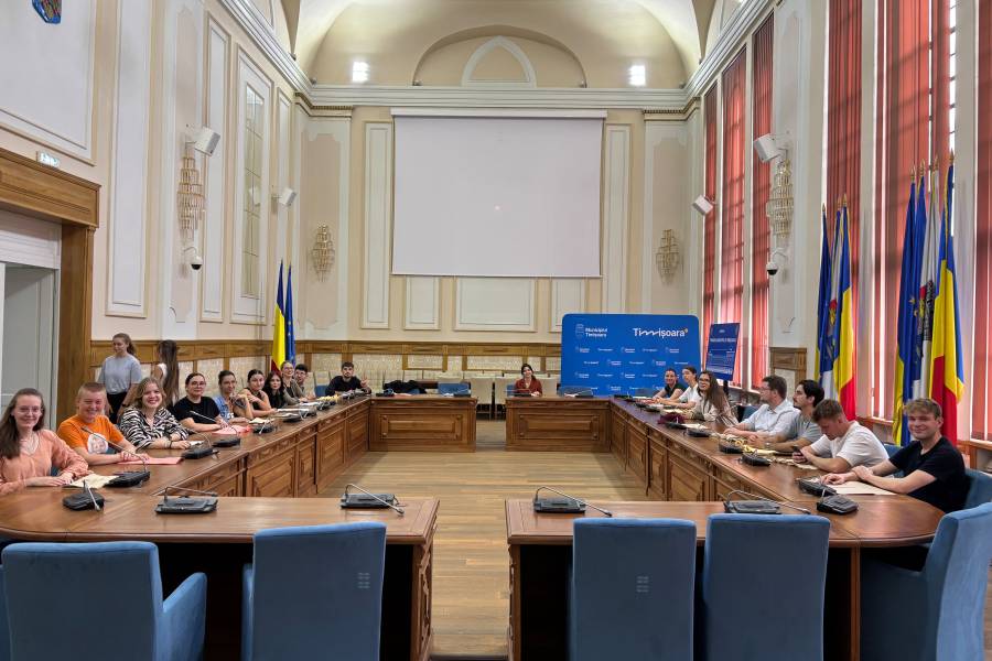 Das Rathaus von Timișoara: die Jugendlichen sitzen rund um den riesigen U-förmigen Tisch auf blauen Stühlen.