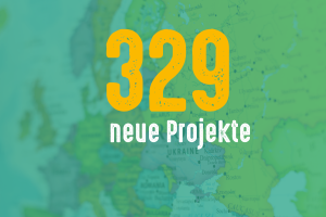 Das Bild zeigt die Zahl 329, darunter den Text "neue Projekte". Im Hintergrund ist eine Europa-Karte zu sehen.