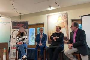 Das Foto zeigt eine Podiumsdiskussion mit vier Personen, die auf Hockern sitzen. Im Hintergrund Banner mit der Aufschrift "Gemeinsam gegen Menschenhandel" und das Logo von Renovabis. Eine Person hält ein Mikrofon.