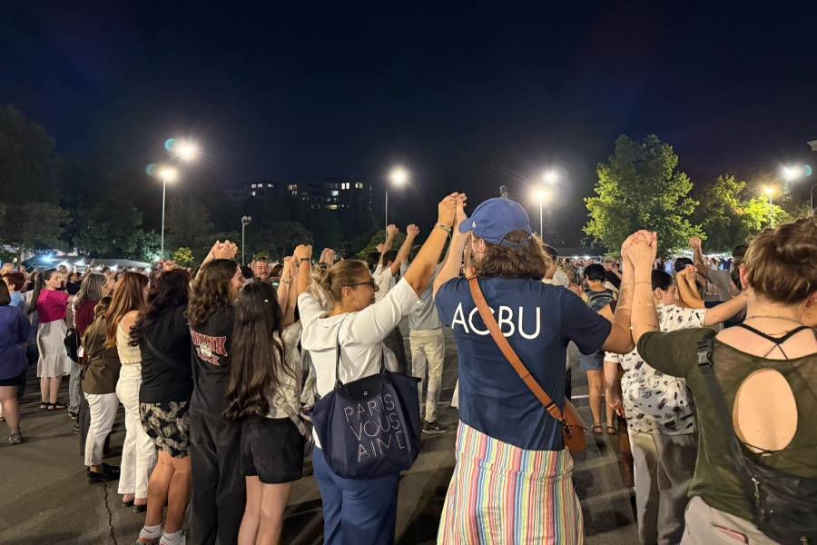 Eine Reihe von jungen Menschen, die mitten in Jerewan tanzen und sich dabei an den in die Luft erhobenen Händen halten.