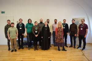 Eine Gruppe Menschen steht nebeneinander. Im Hintergrund ist ein Plakat der Renovabis-Jahresaktion zu sehen.