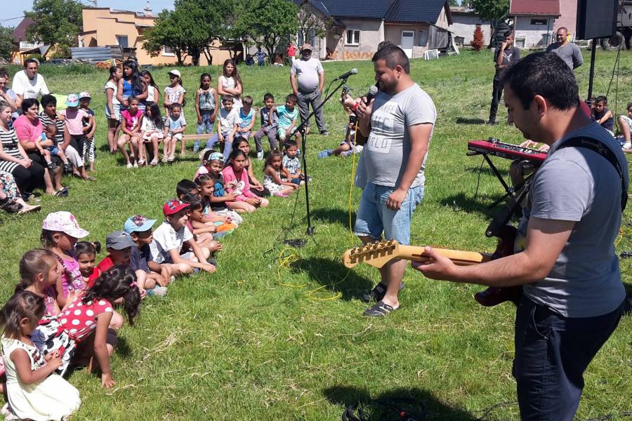 Musiker vor einer Gruppe von Kindern auf einer Wiese