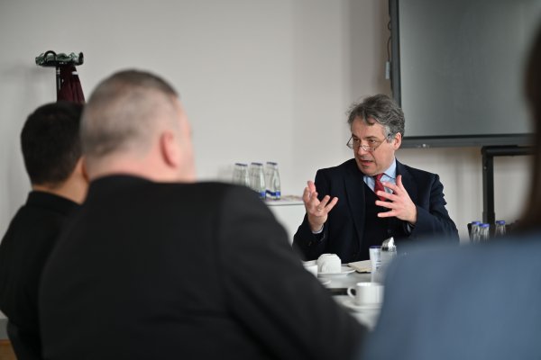 Das Bild zeigt Dr. Ingenlath am rechten Rand, der gerade spricht und die Hände leicht vor sich hebt. Ihm gegenüber sitzen die ukrainischen Gäste mit dem Rücken zum Betrachter.