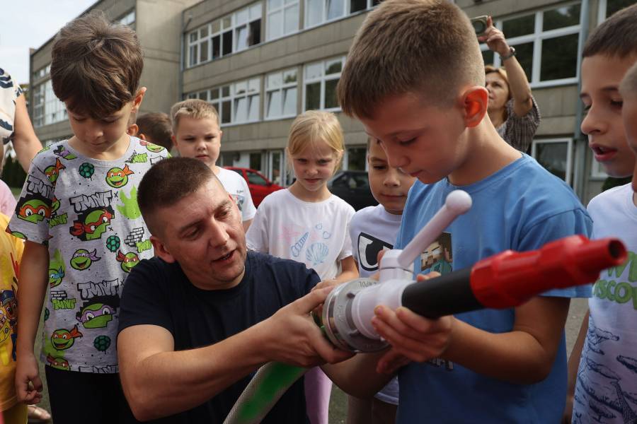 Jovica Vučinić hält zusammen mit einem Schüler eine Feuerwehr-Spritzpistole in der Hand und erklärt den Kindern, wie die Feuerwehr im Notfall arbeitet.
Schülerinnen
und Schülern das
richtige Verhalten im Notfall.