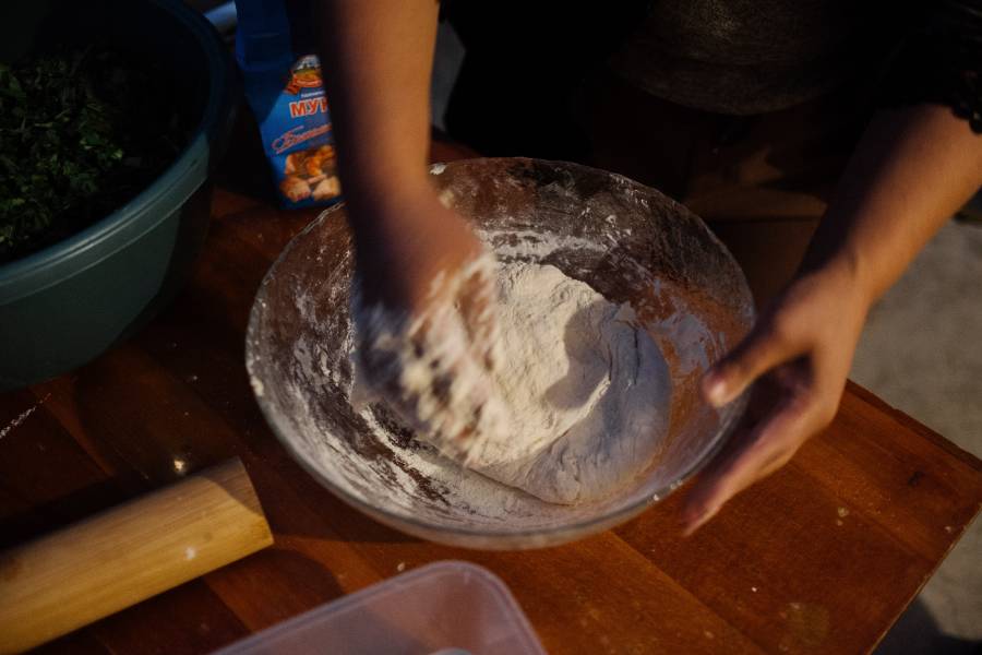 Eine Schüssel mit Mehl, Wasser und Salz, die gerade zum Teig für die Jingalov Hats verknetet werden.