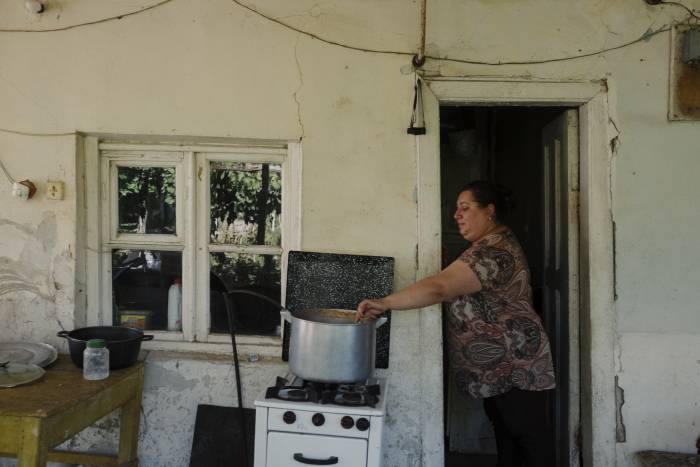 In einem schlichten neuen Zuhause bereitet eine Frau das Essen für ihre Familie zu.<br><small class="stackrow__imagesource">Quelle: Maximilian Gödecke </small>