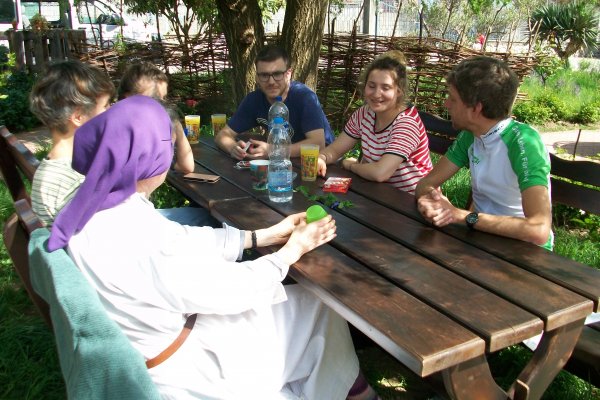 Menschen an einem Holztisch im Garten