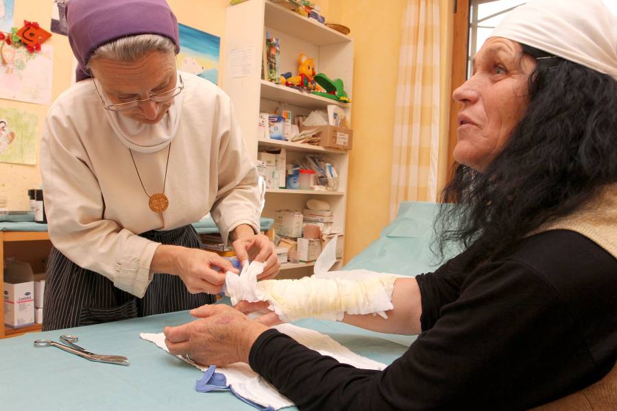 Ordensfrau verbindet den Arm einer Frau