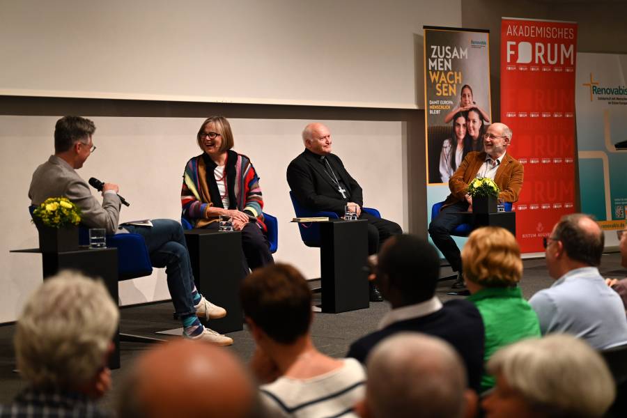 Bild der Podiumsdiskussion. Von rechts nach links sitzen Prof. Harald Lesch in einer beigen Jacke, der Belgrader Erzbischof László Kardinal Német SVD sowie Eva Maria Welskop-Deffaa vom Caritas-Verband aus Berlin. Ganz links Moderator Daniel Wirsching (Augsburger Allgemeine Zeitung).
