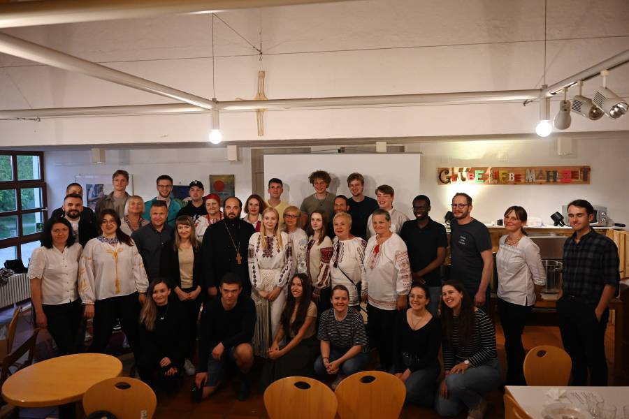 Eine Gruppe von jungen Männern und Frauen, teilweise in ukrainischer Tracht, haben sich zum Gruppenfoto aufgestellt im Rahmen der Veranstaltung "Junge Stimmen aus der Ukraine."