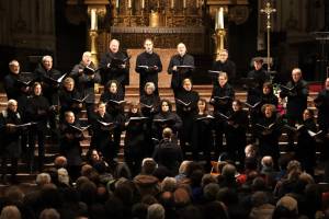 Das Bild zeigt die Sängerinnen und Sänger des Heinrich-Schütz-Ensembles bei einem Auftritt in einer Kirche vor Publikum.