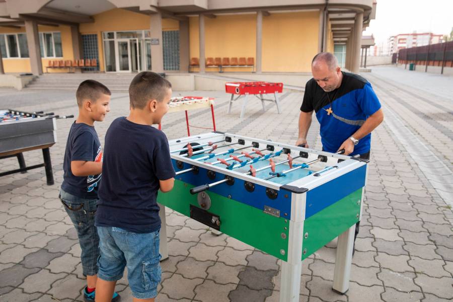 Pater Dominik spielt mit zwei Kindern Tischtennis