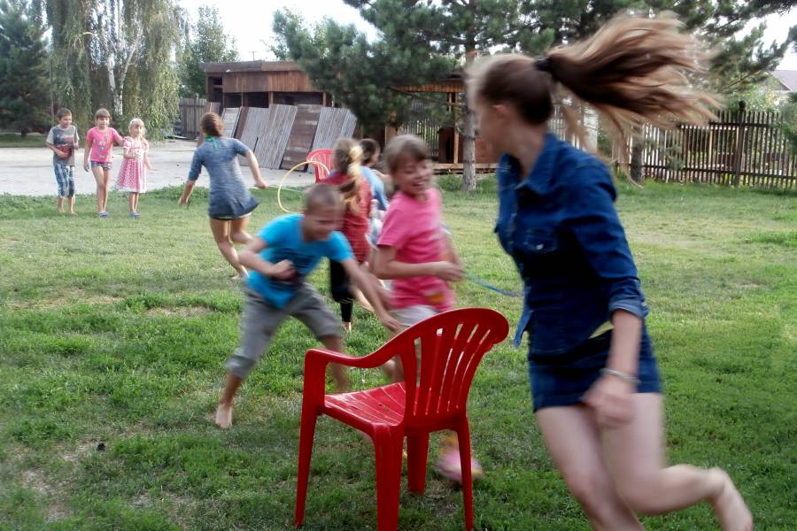 Spielende Kinder auf einer Wiese.